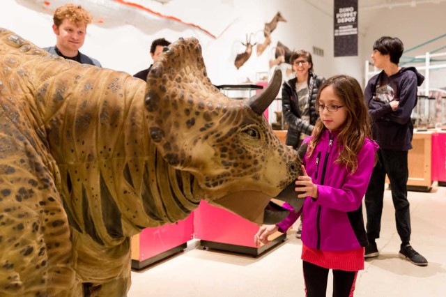 Child meeting a dinosaur puppet in the Discovery Center