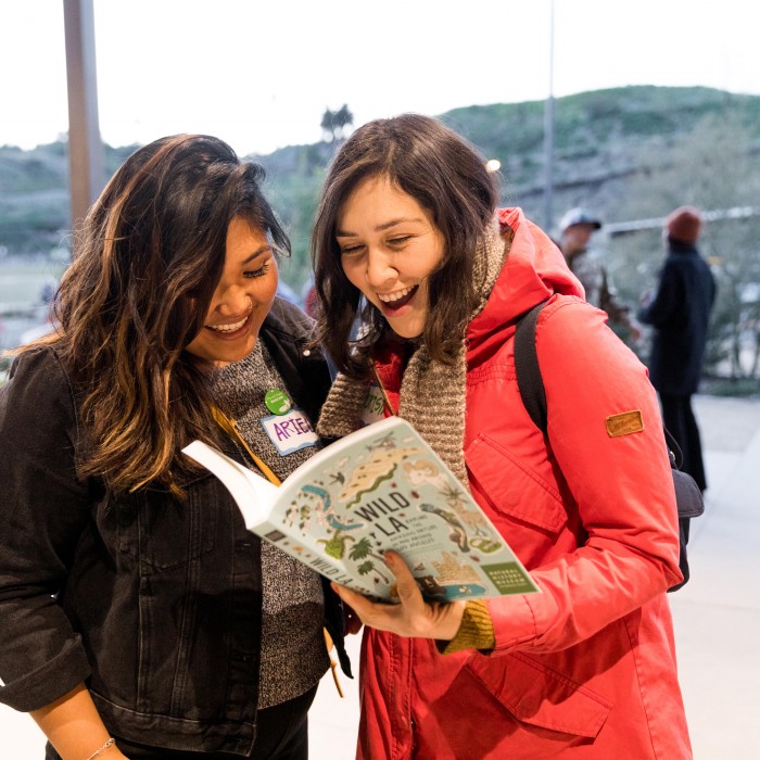 two women reading Wild LA book at community science super project party