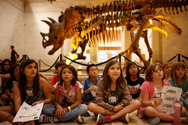 Kids sit in front of Dueling Dinos.